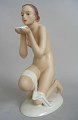 Porcelænsfigur 
af siddende 
nøgen kvinde 
med skål, 
koldbemalet, 
20. årh. 
Tyskland. 
Pirkenhammer. 
...