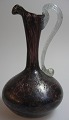 Italiensk 
glaskande, 20. 
årh. i brunligt 
glas med klar 
glas hank. H.: 
14,5 cm.