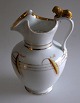Løvekande, 
chokolade, o. 
1900. Hvidt 
porcelæn med 
gulddekor og 
bemalinger i 
form af aks. 
H.: 26 ...