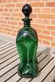 Karaffel eller 
klukflaske i 
mørkegront glas 
med påsat hals, 
fra dansk 
glasværk og fra 
omkring år ...