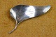 Broche af sølv 
udformet som et 
tragtformet 
asymmetrisk 
blomsterblad. 
Stemplet 
"Original 
Ulrich" ...