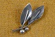 Broche af sølv 
udformet som 
lille kvist med 
2 knopper og 2 
buet blade. 
Stemplet 
Sterling  COF 
...