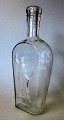 Lommel&aelig;rke 
- snapse flaske 
- Fyens 
Glasv&aelig;rk, 
1903. Danmark. 
Klar glas. 
Dekoration ...