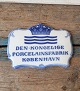 Royal 
Copenhagen 
forhandler 
plakette med 
teksten "Den 
Kongelige 
Forcelænsfabrik 
København"
No. ...