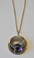 Finsk 
halssmykke i 
sterling sølv 
med violet 
sten. 20. årh. 
Dia.: 3 cm. 
Stemplet. Med 
tilhørende ...