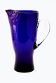Blå glaskande 
med 
sammenpresset 
tud, 
isterningstop. 
Højde 21,5 cm. 
Fin stand. 
Pris: 295 kr