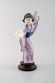 Lladro, 
Spanien. Stor 
figur i 
glaseret 
porcelæn. 
Geisha med 
vifter. 
1900-tallet.
Måler: 29,5 x 
...
