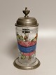 Emaljedekoreret 
ølkrus med tin 
låg
Tyskland 
1800-tallet
Højde med gæk 
24,5cm.
