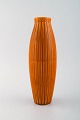 Bo fajans, 
Sverige. Vase i 
glaseret 
keramik med 
riflet korpus. 
Smuk glasur i 
mørke orange 
...