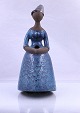Keramik dame 
med fødder. 
Damen er i blå 
kjole, håret er 
i knold og 
hænderne er 
foldet ...