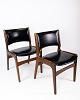 Et sæt stole i 
teak og med 
sort læder, 
designet af 
Erik Buch i 
1960'erne, 
udstråler en 
tidløs ...