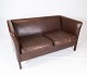 Den 
to-personers 
sofa i 
mørkebrunt 
læder, dansk 
designet og 
fremstillet af 
Stouby 
Møbelfabrik i 
...