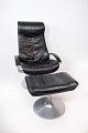 Lænestol med 
skammel 
polstret i sort 
læder og stel 
af metal, af 
Dansk design 
fra 1970erne. 
...