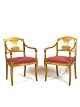 Et par 
senempire 
hvilestole i 
birk, polstret 
med rødt stof 
og fra omkring 
1840'erne, 
udgør et ...