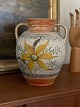 Lertøjs vase 
med stor gul 
blomst og 
hanke, 20. 
århundrede, 
cirka 
1940'erne. 
Højde 23 ...