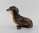 Porcelænsfigur. 
Siddende 
gravhund. 
1930/40'erne.
Måler: 23 x 17 
cm.
I flot stand.
Stemplet.