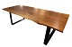 Plankebord af 
egetræ og 
rammestel af 
sort metal, af 
2 massive 
planker med 
naturkanter. 
Bordet er ...