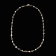 Halskæde i 14k 
guld med 
perler.
Stemplet 585.
L. 45 cm.
Perler diam. 
0,5 cm.
Vægt 10,1 g. 
...
