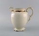 KPM, Berlin. 
Royal Ivory 
kande i 
cremefarvet 
porcelæn med 
gulddekoration. 
1920'erne.
Måler: ...