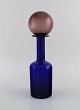Otto Brauer for 
Holmegaard. 
Vase/flaske i 
blåt mundblæst 
kunstglas med 
lilla kugle. 
1960'erne. ...