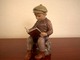 Dahl Jensen 
Figur af 
læsende dreng.
Dekorationsnummer 
1096. 
2. sortering. 
Højde 14,5 ...