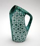 Michael 
Andersen, 
Bornholm, Grøn 
turkis 
kande/vase med 
hvidt 
reliefmotiv og 
hank. Nr. 5681. 
...