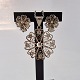 Smykkesæt med 
snirkler af 
sølvtråde 
formet som 
blomster
Øreklips 
stemplet 925s
Vedhæng ...