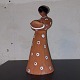 Figur I keramik 
af kvinde, der 
fungerer som 
lysestage. 
Delvist 
glaseret i hvid 
og sort. ...