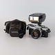 Analog kamera 
med Zuiko 50mm 
1.8 objektiv og 
blitz med sort 
læderrem og 
mørkebrun 
læderetui med 
...