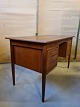 Skrivebord i 
fineret 
teaktræ, fra 
1960erne.
Det har 
brugsspor.
Højde 75cm 
Bredde 129cm 
Dybde 64cm