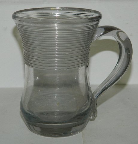 Hanke mugMug with handle - Aalborg Glasswork late 19th. century. Decorated with 
"thread" on top of the bowl. Cracks in the glass at the top. 10 ½ cm high.