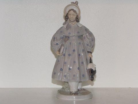 Royal Copenhagen 
Sjælden Art Nouveau figur - Pige i fin frakke med parably og bog