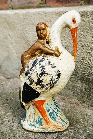 Figure of a stork as a piggy bank with a baby on its back