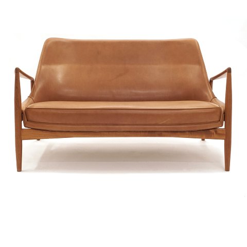 Ib Kofod-Larsen Sælen topersoners sofa i patineret 
 cognac farvet læder. Ib Kofoed-Larsen, 1921-2003, 
formgav Sælen i 1957. Stel i teak. Udført af Brdr. 
Petersen Polstermøbelfabrik. L: 138cm