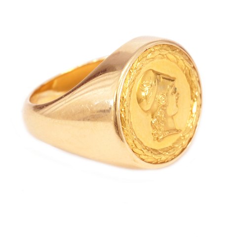 Georg Jensen Doktorring aus 18kt Gold mit 23kt 
Gold Platte mit dem Porträt Minervas. Ringgr. 
66-67. G: 23,7gr