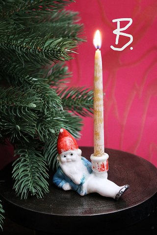 Old Christmas candlestick in  bisque of Santa Claus lying down holding a small Christmas candle...