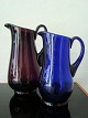 Holmegaard 
kunstglas 
mælkekander.
Begge med 
"kuglet" bund.
Den 
ametystfarvede 
er 24 cm høj og 
...