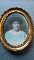 Oval guldramme 
med koloreret 
foto af kvinde.
Foto stemplet 
- Chr. Andersen 
Fotograf ...