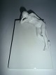 Hvid 
kvindefigur i 
porcelæn, 
liggende på 
plade fra 
Bing&Grøndahl, 
Danmark ca. 
1920.
11½cm. bred 
...