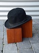 Sort Bowlerhat. 
Hatten har en 
mindre rift i 
toppen. L: 31 
cm. B: 26 cm.
Varenr.: 
234710