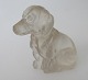 Siddende grav 
hund, i glas, 
19. &aring;rh. 
Tyskland. 
Presset 
matteret glas. 
H.: 3,7 cm.