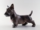 Dahl Jensen 
nummer 1066, 
Skottehund 
stående (DJ) 
Måler 17 cm.
Mærket med 
kongekrone og 
DJ ...