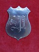 Frakkeskjold i 
830S sølv med 
initialer 
"S.P." i pæn 
stand.
Stempel: 830S 
- P.E
5,5 x 4cm