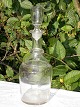 Gammel 
cylinderformet 
glas karaffel 
omlagt med rund 
rigle. Anhæftet 
i bunden. Højde 
med prop, ...