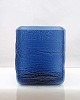 Firkantet blå 
vase i 
struktureret 
glas. Vasen kan 
også bruges som 
urtepotteskjuler.
 Intakt.
H. ...