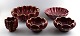 Collection of 
'Red Rubin' 
pottery with 
red glaze with 
gold, 
Upsala-Ekeby, 
Gefle. Design 
Arthur ...