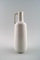Tysk kande i 
hvidt porcelæn, 
moderne design, 
riflet.
I perfekt 
stand.
Måler : 22,5 
cm.
Stemplet.