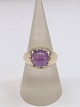 Ring i 14 karat 
guld med en 
rund lilla 
safir á ca. 
10,0mm i 
diameter. 
Ringstr. 60½ 
...