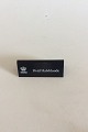 Royal 
Copenhagen 
Forhandler 
Reklame Skilt i 
Plastik "Hvid 
Halvblonde".
Måler 10,5cm x 
4,2cm