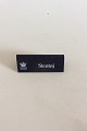 Royal 
Copenhagen 
Forhandler 
Reklame Skilt i 
Plastik 
"Stentøj".
Måler 10,5cm x 
4,2cm
